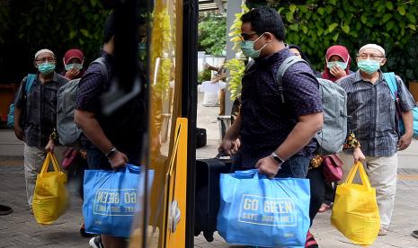 Sejumlah pasien COVID-19 menaiki bus Sekolah yang akan membawa mereka menuju Rumah Sakit Darurat Wisma Atlet di Puskesmas Kecamatan Duren Sawit, Jakarta.