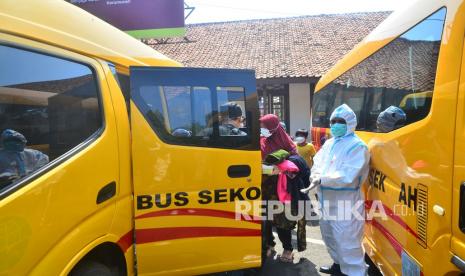 Sejumlah pasien Covid-19 naik ke bus sekolah saat akan dipindahkan dari Kudus di Jawa Tengah, Senin (7/6/21). Sebanyak 23 pasien Covid-19 yang terdiri atas aparatur sipil negara dan keluarganya di Kudus dipindahkan ke tempat karantina terpusat di Asrama Haji Donohudan, Boyolali, Jawa Tengah, guna mendapatkan pelayanan kesehatan yang lebih baik serta mencegah penularan Covid-19 yang lebih luas. 