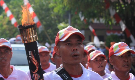 Sejumlah pasukan membawa obor saat kirab Api PON yang diambil dari sumber api alam di Indramayu, Jawa Barat, Senin (5/9). 