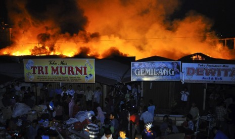 Sejumlah pedagang berusaha mengeluarkan barang dagangan mereka saat terbakarnya Pasar Cik Puan Pekanbaru, Riau, Senin malam (6/7). 