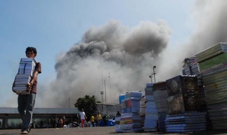 Sejumlah pedagang berusaha untuk memindahkan barang dagangannya dari lalapan api yang membakar gedung Pasar Senen, Jakarta Pusat, Jumat (25/4).