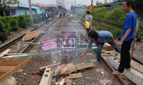 Sejumlah Pedagang dan mahasiswa berdemo dengan memblokir rel kereta di stasiun Pondok Cina, Depok, Jawa Barat, Senin (14/1). (Republika/Agung Fatma Putra)