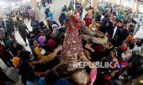 Sejumlah pedagang dan pembeli berebut gunungan berisi cabai dan bawang saat peresmian Pasar Legi Solo, Jawa Tengah, Kamis (20/1/2022). Pasar Legi yang terbakar pada 2018 tersebut telah direvitalisasi dan diresmikan dengan kapasitas bangunan pasar berjumlah 306 unit kios, 2190 los dan plataran 700 pedagang, yang diharapkan meningkatkan roda perekonomian di Kota Solo.