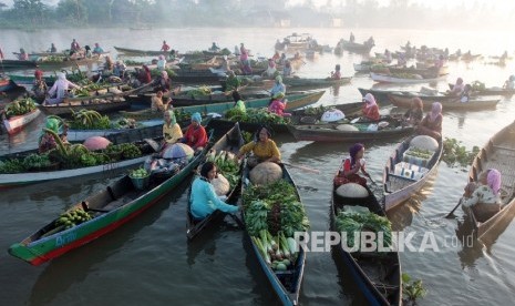 Sejumlah pedagang dan pembeli menggunakan sampan (Jukung) melakukan transaksi jual beli di Pasar Terapung Lok Baintan, Banjar, Kalimantan Selatan, Jumat (12/10). Beraneka hasil bumi seperti buah dan sayuran serta kebutuhan pokok lainnya di perjualbelikan d