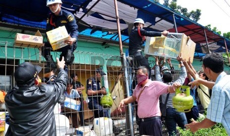  Sejumlah pedagang kaki lima (PKL) dibantu petugas mengangkut barang mereka saat penertiban PKL di Stasiun Pasar Minggu, Kamis (18/4). (Republika/Rakhmawaty La'lang)