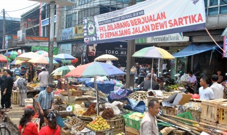 Sejumlah pedagang kaki lima (PKL) menjual barang dagangannya di bawah spanduk larangan berjualan untuk PKL di jalan Dewi Sartika, Kota Bogor, Jawa Barat