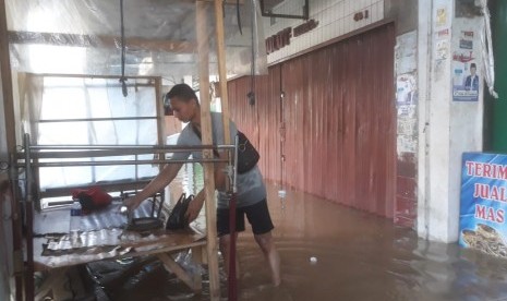 Sejumlah pedagang kaki lima (PKL) yang menggelar lapak di depan toko-toko di pasar Dayeuhkolot terpaksa tidak berjualan. Akibat terendam banjir, Senin (8/4).