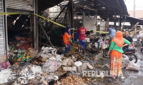 Sejumlah pedagang memeriksa kiosnya dan mengumpulkan barang-barang yang tersisa dalam peristiwa kebakaran yang menghanguskan 116 kios dan 126 pedagang kakai lima (PKL) hangus dalam peristiwa kebakaran di Pasar Gedebage, Ahad (15/7).