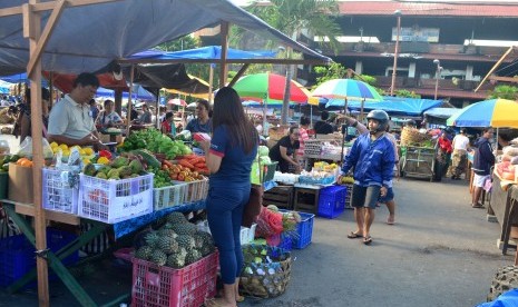 Sejumlah pedagang menggelar lapak dagangan mereka di lahan parkir Pasar Badung, Kota Denpasar, Bali.