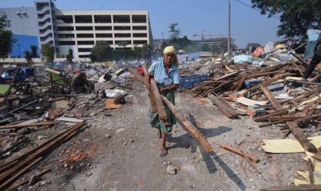 Sejumlah pedagang mengumpulkan kembali sisa puing bangunan yang layak di tengah bongkaran kios kawasan Terminal Depok, Jawa Barat, Kamis (9/10).(Republika/Rakhmawaty La'lang)