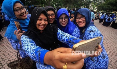 Sejumlah Pegawai Negeri Sipil (PNS) berfoto dan halal bihalal usai mengikuti apel gabungan hari pertama masuk kantor setelah cuti bersama Idul Fitri 1439 Hijriah di Aceh Utara, Aceh, Kamis (21/6).