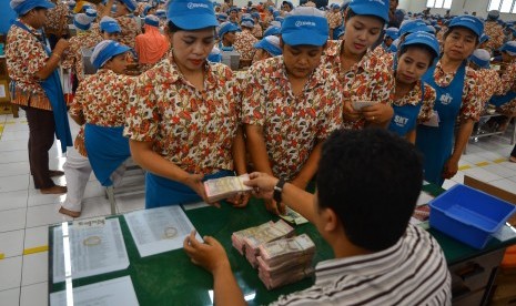 Sejumlah pekerja antre saat pembagian uang Tunjangan Hari Raya 