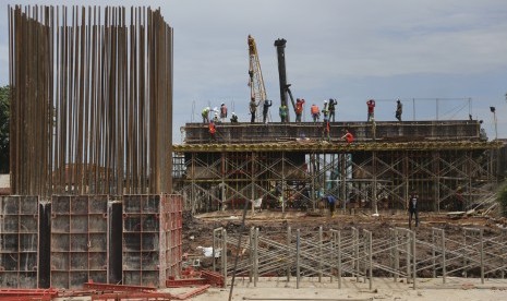 Sejumlah pekerja dengan alat berat mengerjakan proyek pembangunan fly over Keramasan, Palembang, Sumatera Selatan, Jumat (31/3). 