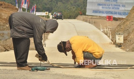 Petugas memasang pita kejut di jalan menurun menuju jalur darurat jembatan Kali Kenteng, di ruas tol fungsional Salatiga- Kartasura, Selasa (5/6). Pemasangan pita kejut ini untuk mengurangi kecepaatan kendaraan yang akan memasuki jalur darurat.