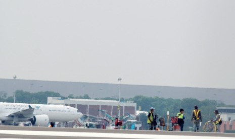 Sejumlah pekerja melakukan pengerjaan persiapan akhir pengoperasian Landasan Pacu atau Run Way 3 sisi utara Bandara Soekarno Hatta, Tangerang, Banten, Senin (16/12/2019). 