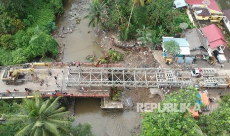 Sejumlah pekerja memasang panel jembatan sementara di Batang Kalu, Jalur Padang - Pekanbaru, Kayutanam, Padangpariaman, Sumatera Barat, Kamis (13/12/2018). 