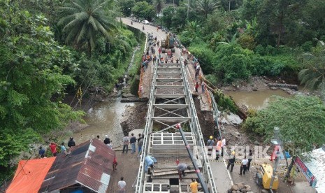 Sejumlah pekerja memasang panel jembatan sementara di Batang Kalu, Jalur Padang - Pekanbaru, Kayutanam, Padangpariaman, Sumatera Barat, Kamis (13/12/2018). 