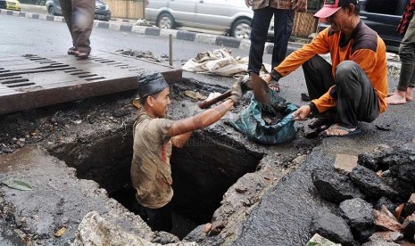 Sejumlah pekerja membersihkan endapan sampah di saluran air Jalan H.O.S Cokroaminoto, Jakarta Pusat, Senin (24/2).