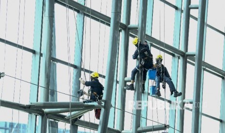 Sejumlah pekerja membersihkan kaca Terminal 3 Bandara Soekarno-Hatta, Tangerang, Banten, Jumat (5/4).