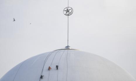 Sejumlah pekerja membersihkan kubah Masjid Istiqlal, Jakarta, Selasa (29/3/2022). Masjid Istiqlal mulai berbenah diri menjelang bulan Ramadhan yang jatuh pada April mendatang.