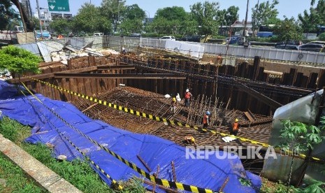 Sejumlah pekerja membongkar rangka yang akan dijadikan tiang penyangga pada proyek Light Rapid Transit (LRT) yang amblas di depan Menara Saidah, Jalan MT Haryono, Jakarta, Jumat (13/10).