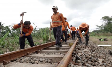 Sejumlah pekerja memperbaiki rel kereta yang ambles akibat banjir dan menyebabkan sejumlah perjalanan KA terganggu hingga 10 jam di pintu kereta Jeruklegi Kulon, Jeruklegi, Cilacap, Jateng, Sabtu (8/10/2022). Lima titik lintas kereta api di wilayah jalur selatan DAOP V Purwokerto yang ambles karena banjir sudah bisa dilewati rangkaian KA dengan aman pada pukul 12.25 WIB. 