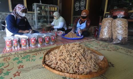 Sejumlah pekerja mengemas keripik jamur di sebuah rumah produksi di Glodogan, Klaten Selatan, Klaten, Jawa Tengah, Rabu (5/1/2022). Menurut pelaku usaha kecil menengah (UKM) keripik jamur tersebut kenaikan harga minyak goreng menjadi Rp41 ribu per dua liter memaksa pihaknya menaikan harga jual keripik jamur dari Rp12 ribu menjadi Rp14 ribu per 100 gram dan Rp23 ribu menjadi Rp25 ribu per 250 gram. 