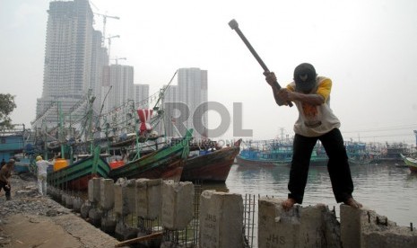 Sejumlah pekerja mengerjakan peninggian tanggul di Muara Angke, Jakarta Utara, Kamis (7/11). (Republika/Rakhmawaty La'lang)