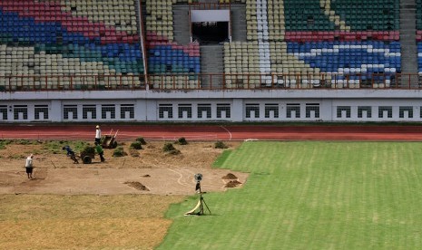 Sejumlah pekerja menggarap pergantian rumput lapangan Stadion Wibawa Mukti di Cikarang, Kabupaten Bekasi, Jawa Barat, Sabtu (26/5).