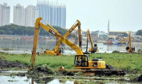 Sejumlah pekerja menggunakan alat berat melakukan pengerukan di Waduk Pluit, Jakarta Utara, Selasa (6/5). (Republika/Rakhmawaty La'lang)