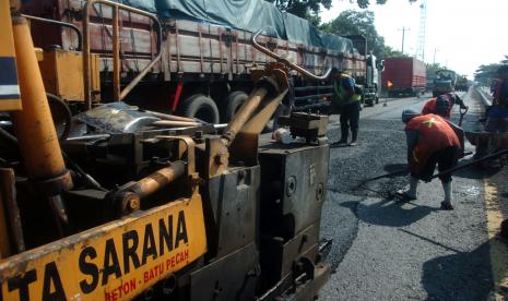 Sejumlah pekerja menggunakan alat berat melakukan perbaikan jalan di jalur pantura, Demangharjo, Kabupaten Tegal, Jawa Tengah (ilustrasi) 