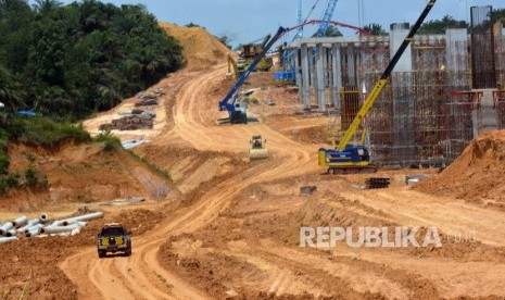 Sejumlah pekerja menggunakan alat berat untuk menyelesaikan proyek jalan tol. ilustrasi