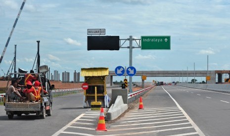 Sejumlah pekerja menumpang mobil bak di kawasan proyek Tol Palindra di Pemulutan Kabupaten Ogan Ilir, Sumatera Selatan, Selasa (10/10). Bagian seksi satu Tol Palindra sepanjang tujuh kilometer dari gerbang Palembang menuju Pemulutan tengah dalam proses persiapan inspeksi kelayakan operasi untuk siap dilintasi.