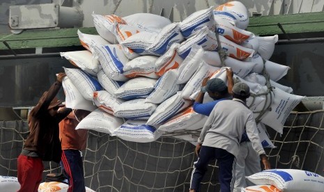 Sejumlah pekerja menurunkan beras impor asal Vietnam dari kapal di Pelabuhan Indah Kiat, di Merak, Cilegon, Banten, Selasa (10/7).