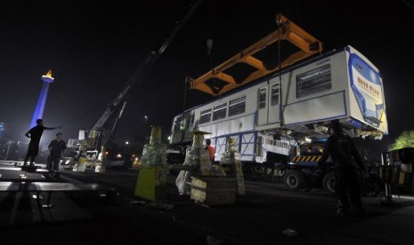  Sejumlah pekerja menurunkan gerbong monorail di halaman Lapangan Monas, Jakarta, Sabtu (8/6) dini hari.  (Antara/Zabur Karuru)