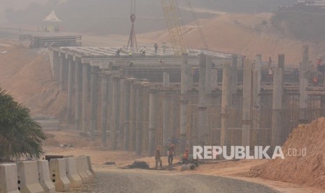 Sejumlah pekerja menyelesaikan pembangunan jalan tol Pekanbaru - Dumai ditengah kabut asap kebakaran hutan dan lahan di daerah Minas Kabupaten Siak, Riau, Rabu (18/9/2019).