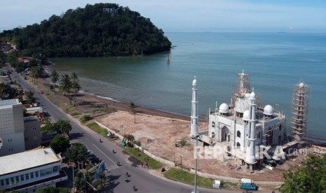 Sejumlah pekerja menyelesaikan pembangunan kubah masjid, di Pantai Padang, Sumatera Barat, Minggu (9/12/2018). 