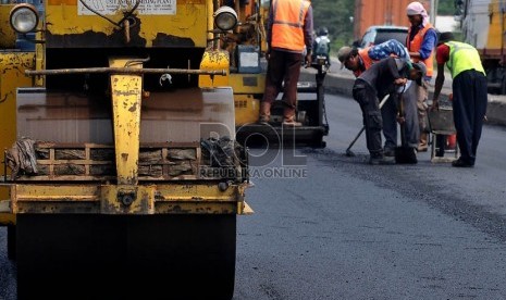   Sejumlah pekerja menyelesaikan perbaikan jalan di jalur pantura wilayah Indramayu, Jawa Barat, Ahad (28/7). (Republika/Prayogi)