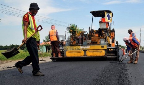   Sejumlah pekerja menyelesaikan perbaikan jalan di jalur pantura wilayah Indramayu, Jawa Barat, Ahad (28/7). (Republika/Prayogi)