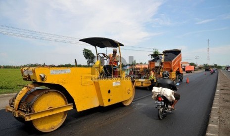   Sejumlah pekerja menyelesaikan perbaikan jalan di jalur pantura wilayah Indramayu, Jawa Barat, Ahad (28/7). (Republika/Prayogi)