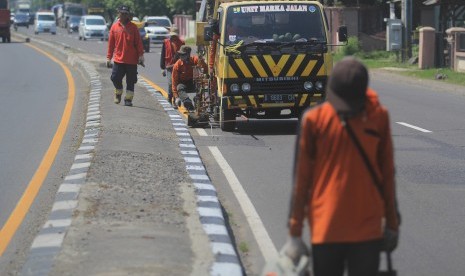 Sejumlah pekerja menyelesaikan proses pengecatan marka jalan di jalur pantura Lohbener Indramayu, Jawa Barat, Senin (20/5/2019).