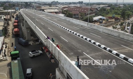 Sejumlah pekerja menyelesaikan proyek pembangunan jalan layang (fly over) simpang Cipendawa di Bekasi, Jawa Barat, Senin (13/1/2020). 