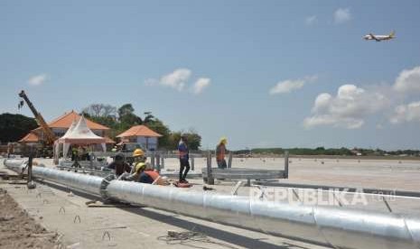 Sejumlah pekerja menyelesaikan proyek perluasan apron Bandara Internasional I Gusti Ngurah Rai, Bali, Selasa (18/9).