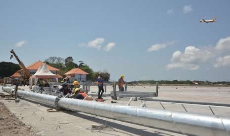 Sejumlah pekerja menyelesaikan proyek perluasan apron Bandara Internasional I Gusti Ngurah Rai, Bali, Selasa (18/9). Pengelola Bandara Internasional I Gusti Ngurah Rai menargetkan verifikasi akhir Kementerian Perhubungan atas proyek pengembangan apron berlangsung akhir September sehingga siap difungsikan sebelum pertemuan Dana Moneter Internasional (IMF) dan Bank Dunia bulan Oktober mendatang. 