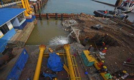 Sejumlah pekerja menyelesaikan renovasi penambahan fasilitas dan kapasistas Dermaga I Pelabuhan Merak di Cilegon, Banten, Rabu (30/3/2022). Pihak pengelola pelabuhan penyeberangan Merak merenovasi pembangunan Dermaga I dengan menambah fasilitas transit penumpang dan kapasitas kapal dari semula lebar 8 meter menjadi 12,5 meter dan kapasitas muatan yang semula 35 ton menjadi 60 ton yang ditargetkan selesai tanggal 15 April 2022 untuk memperlancar arus penyeberangan ke Pulau Sumatera