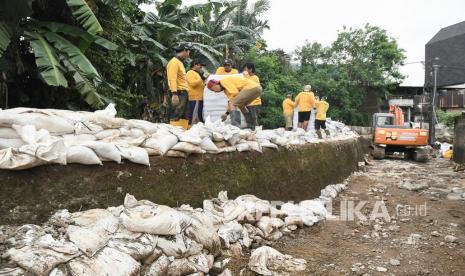 Sejumlah pekerja menyusun karung berisi pasir untuk tanggul sementara di aliran kali Cakung di Jatiasih, Bekasi, Jawa Barat, Kamis (4/11/2021). Dinas Bina Marga dan Sumber Daya Air (DBMSDA) Bekasi membuat tanggul sementara aliran kali Cakung yang jebol pada (2/11) dengan karung pasir untuk mencegah luapan air kali yang menyebabkan banjir.