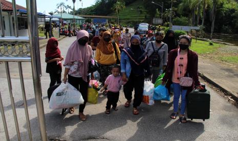 Sejumlah pekerja migran Indonesia Bermasalah (PMIB) memasuki Pos Lintas Batas Negara (PLBN) Entikong di Kabupaten Sanggau, Kalimantan Barat, Kamis (28/4/2022). 