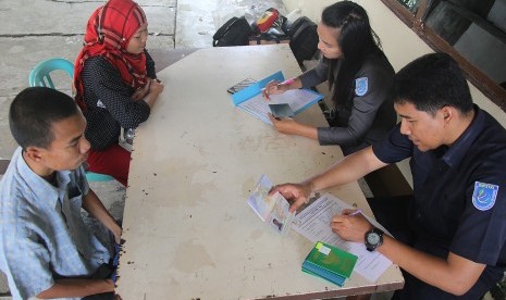 Sejumlah pekerja migran yang dideportasi dari Malaysia diperiksa oleh petugas Pos Pelayanan Penempatan dan Perlindungan Tenaga Kerja Indonesia (P4TKI) Dumai di kota Dumai, Riau, Selasa (12/3/2019).