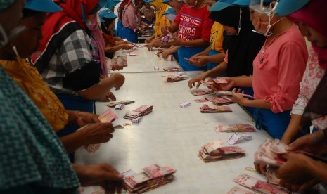 Sejumlah pekerja pabrik rokok menghitung uang Tunjangan Hari Raya (THR) Lebaran 