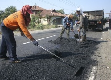 Sejumlah pekerja perbaikan jalan di Jalur Pantura, menjelang mudik lebaran 2011.